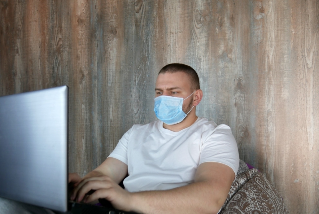 Man laptop mondmasker